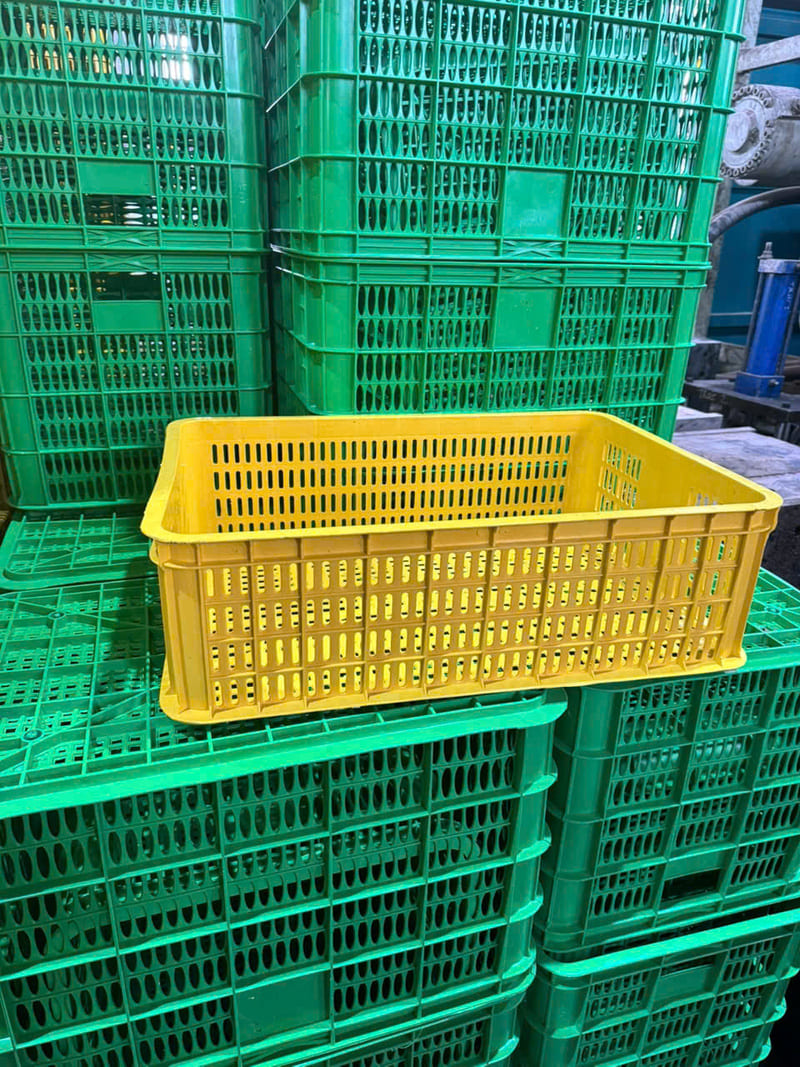 Sóng nhựa vàng thoáng khí, đặt trên chồng sọt xanh, thích hợp bảo quản rau củ quả tươi