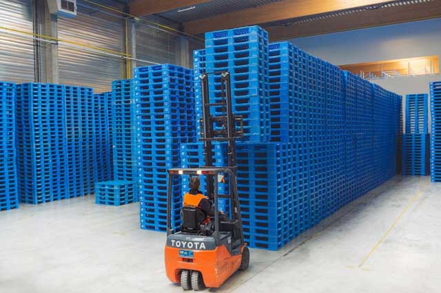 Pallet nhựa hỗ trợ xe nâng trong quá trình lưu trữ và vận chuyển hàng hóa trong nhà máy.